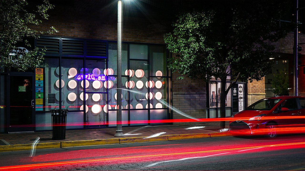 Photo of a city street with glowing light trails from the camera perspective